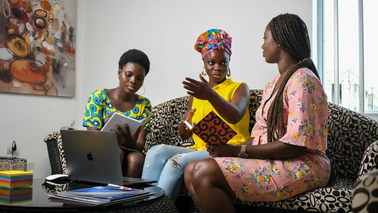 Business owners discussing a website project with a designer around a laptop