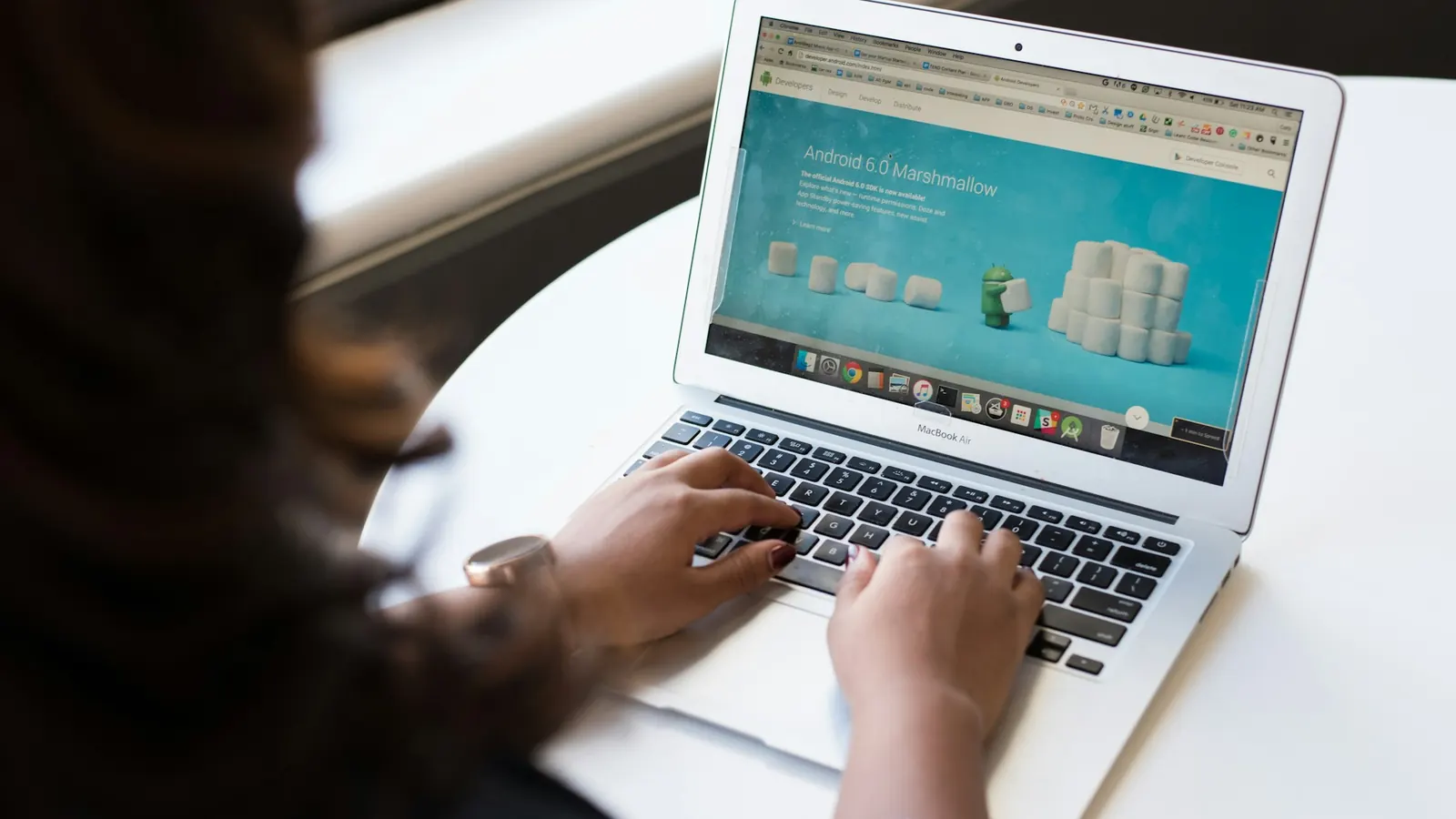 Woman browsing a business website on a laptop while comparing website design options